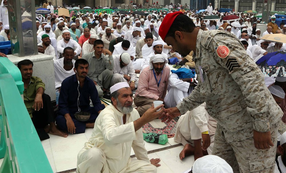 Saudische militair deelt water uit tijdens de Hadj